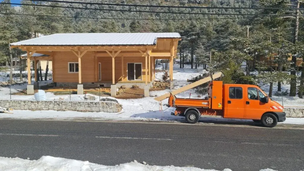 Construction de chalet en bois massif sous la neige à Caille